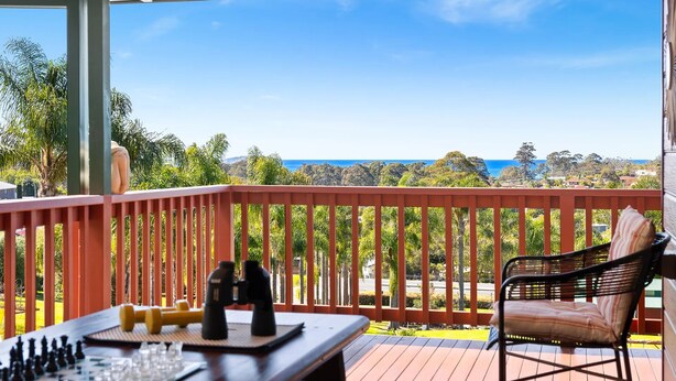 Eine Terrasse mit Schachbrett, Fernglas und Stuhl mit Blick auf eine schöne Aussicht.