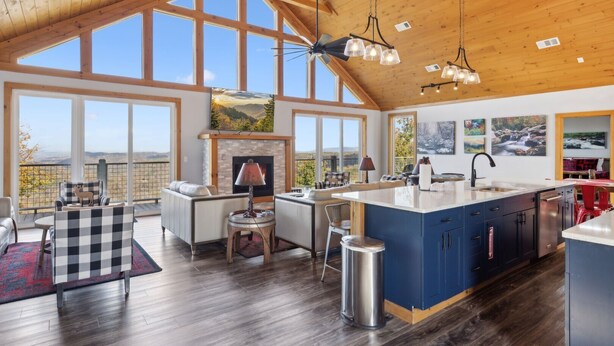 A spacious kitchen with a large island, a fireplace, and a view of the outdoors.
