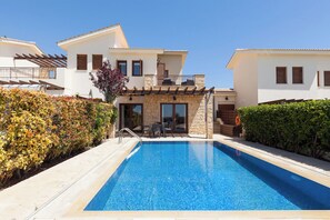 A modern villa with a swimming pool, stone facade, and a patio area. - Luxurious Villa Retreat with Panoramic Views (Paphos)