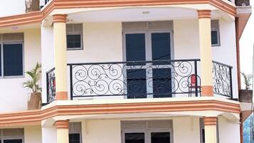 Un immeuble à plusieurs étages, doté de balcons, de grandes fenêtres et d’une entrée centrale.
