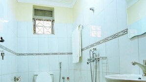 Un baño pequeño con inodoro, ducha y lavamanos.