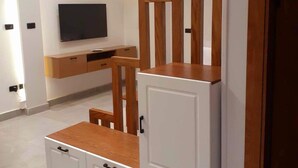 Ein modernes Wohnzimmer mit Flachbildfernseher, Holzmöbeln und Einbauschränken.