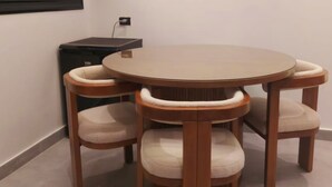 Ein runder Esstisch aus Holz mit sechs Stühlen, jeweils mit gepolstertem Sitz und Rückenlehne.