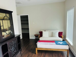 Relax in this stylish living room with a sofa, wooden bench, and large cabinet.