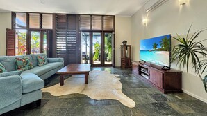 Een woonkamer met een bank, salontafel en een televisie aan de muur.