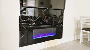 Ett modernt vardagsrum med en stor platt-TV som är monterad på en svart vägg.