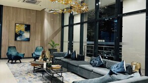 Un salon moderne avec un canapé gris, une table basse et une grande fenêtre.