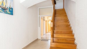 Una scala in legno con corrimano che porta a una porta.