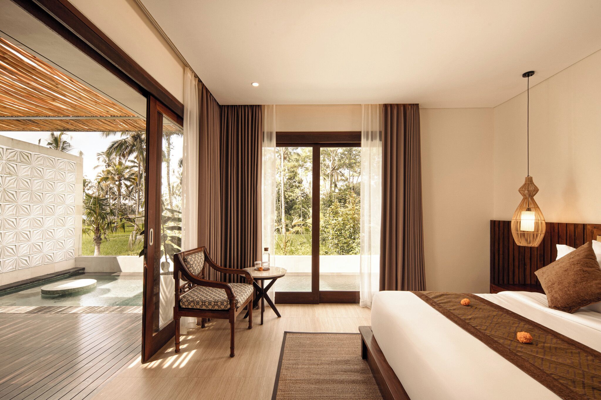 Een moderne hotelkamer met een bed, een stoel, een klein tafeltje en uitzicht op de omgeving.