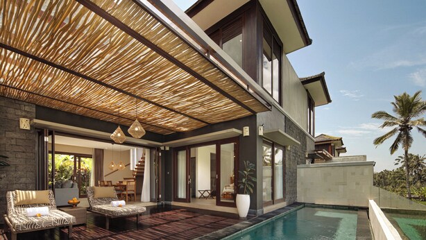 Ein modernes Haus mit Swimmingpool, Sitzgelegenheit im Freien und einem großen Fenster mit Blick auf den Pool.