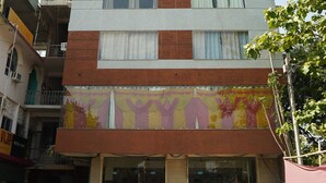 Un edificio a più piani con un locale commerciale al piano terra e una vetrina colorata.