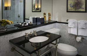 A modern bathroom with a black countertop sink, white toilet, and a large mirror.