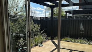 Une pièce dotée d’une porte-fenêtre coulissante donnant sur un patio extérieur.