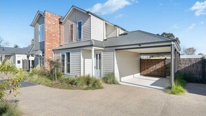 Une maison à deux étages avec un garage fermé et une partie en briques.