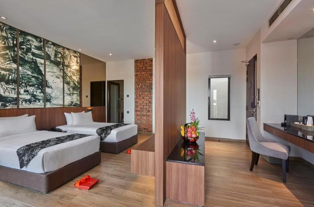 A modern hotel room with two beds, a desk, and a large artwork on the wall.
