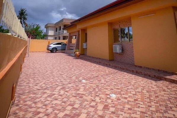 A building with a paved driveway and a parked car.