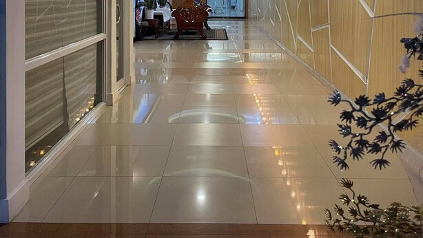 A modern hotel lobby with a polished floor, wooden paneling on the walls, and a seating area with a table and chairs. - Seacliff Suites Hotel & Resort (Pinamalayan)