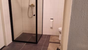 Een douche, een haardroger, handdoeken, toiletpapier