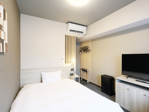A hotel room with a bed, a TV, a wardrobe, a coat rack, and an air conditioning unit. - Hotel Route Inn Grand Kainan Ekimae (Kainan)