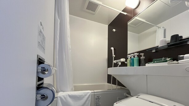 A modern bathroom with a toilet, shower, and sink. - Hotel Route Inn Imabari (Imabari)