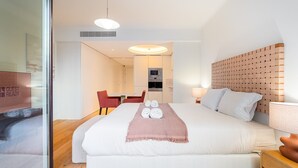 Une chambre d’hôtel moderne équipée d’un grand lit, d’un petit bureau, d’une chaise et d’un four à micro-ondes.
