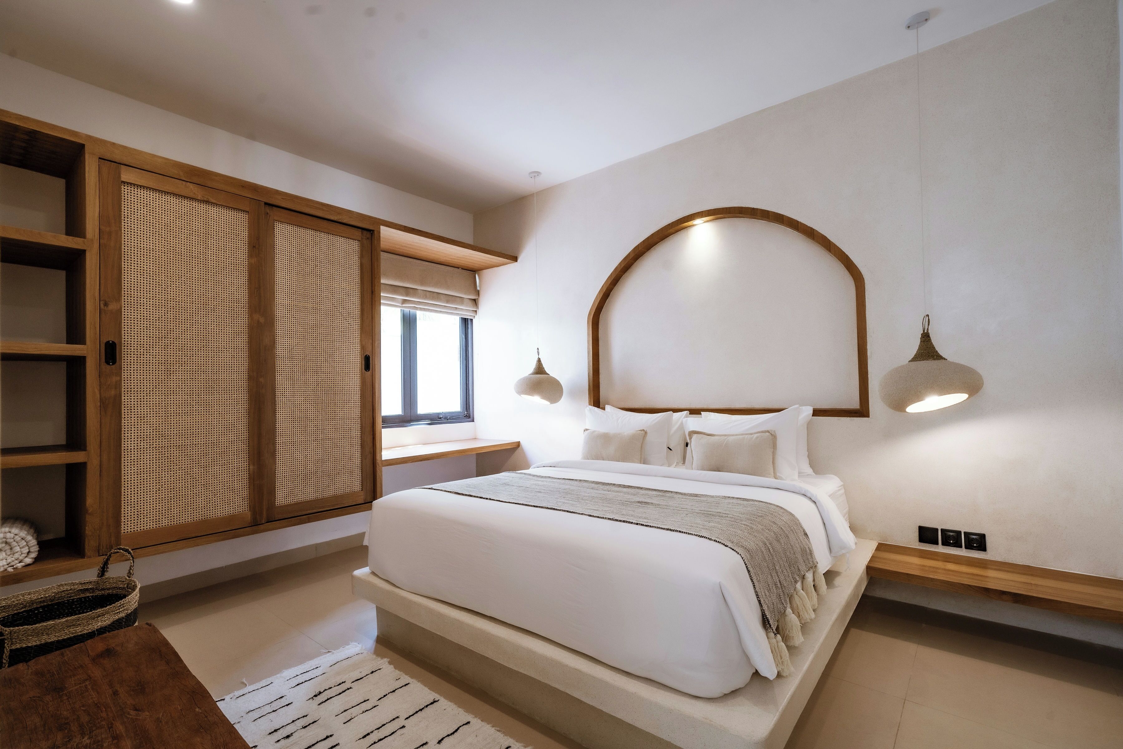 A modern bedroom with a large bed, wooden wardrobe, and a unique ceiling light fixture.