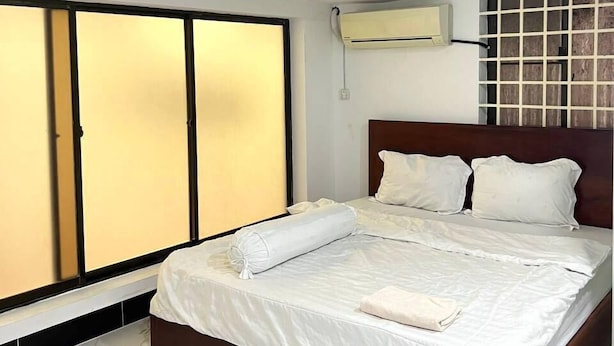 A hotel room with a bed, a wardrobe, and a wall-mounted air conditioner. - Jasminsorium (Phnom Penh)