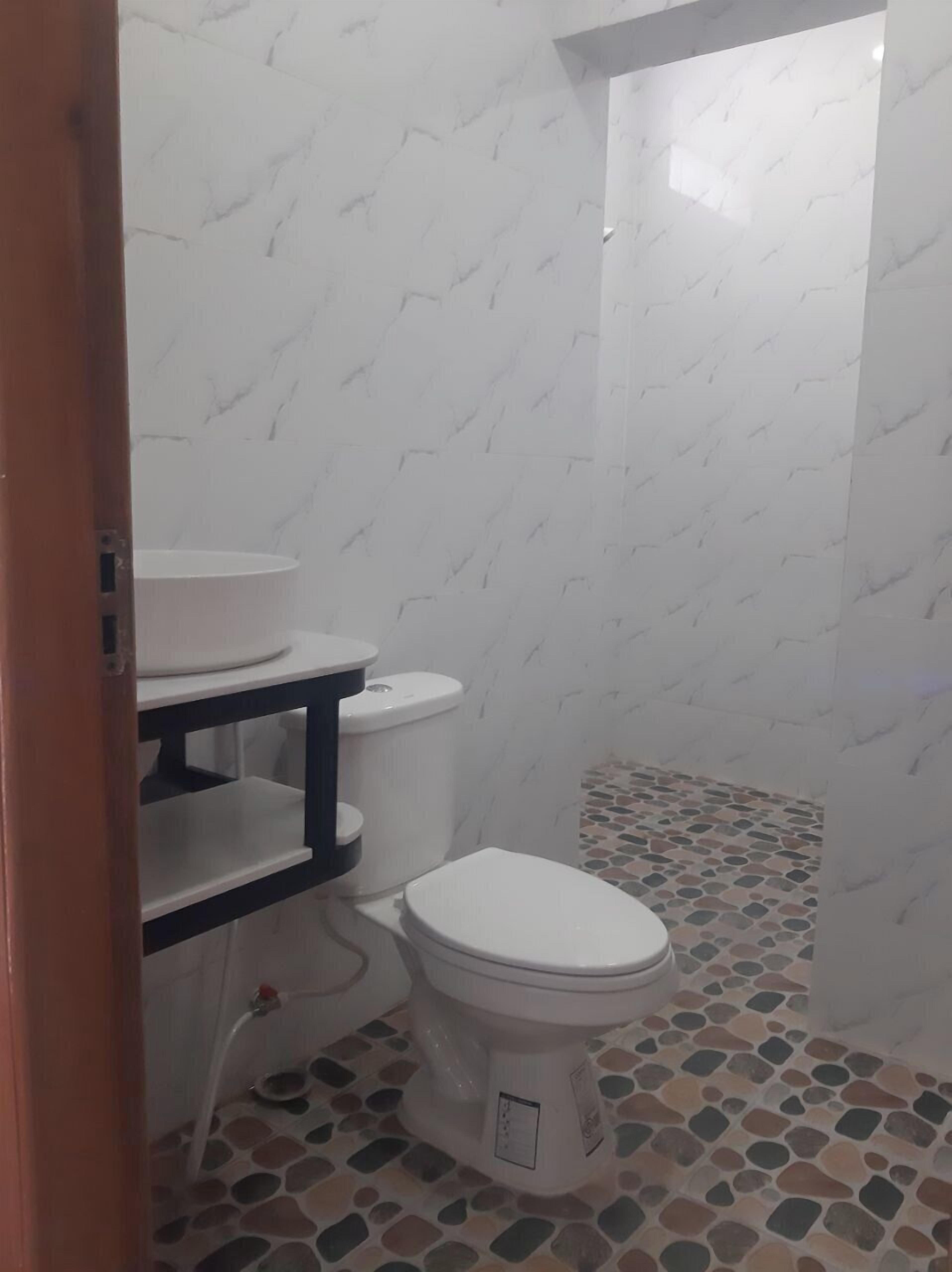 A bathroom with a toilet, a sink, and a shower.