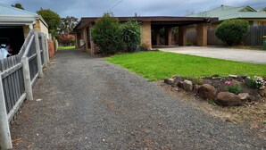 Ein Auffahrtsweg führt zu einem Haus mit überdachter Veranda und Garage.