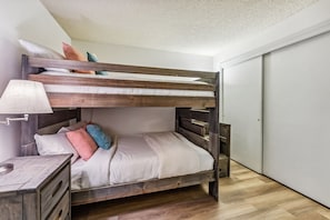 A bunk bed with a wooden frame, white bedding, and a bedside table with a lamp. - Steps to Gondola, Ski-In, 1 Block Main St, Hot Tub (Breckenridge)