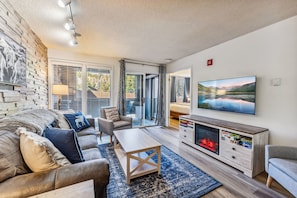 A modern living room with a fireplace, a large TV, and a comfortable seating area. - Steps to Gondola, Ski-In, 1 Block Main St, Hot Tub (Breckenridge)