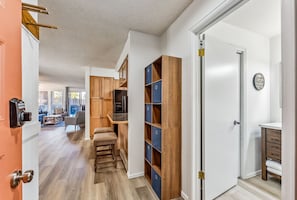 A hallway with a wooden cabinet, a bench, and a door leading to a bathroom. - Steps to Gondola, Ski-In, 1 Block Main St, Hot Tub (Breckenridge)