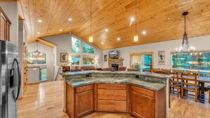 A spacious kitchen with a large island, wooden ceiling, and a dining area with wooden chairs and tables. - Kings Beach Retreat: Hot Tub, Walk to Beach (Kings Beach)