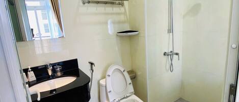 Un baño moderno con inodoro, lavamanos y ducha.