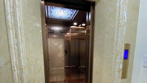 An elevator with a digital display, marble flooring, and decorative wall panels. - Queen Villa 3 Hotel DL - by Bay Luxury (Xuan Huong - Da Lat)