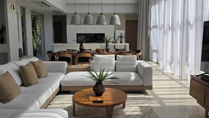 A spacious living room with a high ceiling, a large sofa set, a coffee table, and a dining area in the background. - Mahutsachan Klong Thom (Khlong Thom)
