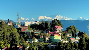 A mountainous village with colorful houses and a prominent communication tower. - Golden Sunview Homesay (Kurseong)