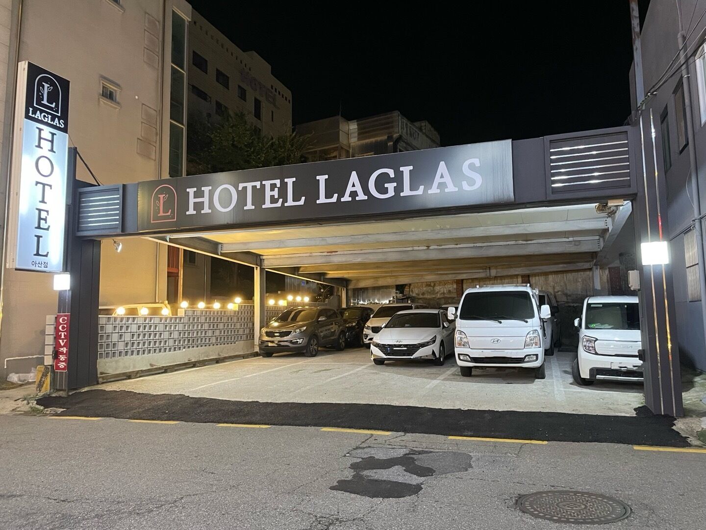 Entrada de hotel con zona de estacionamiento techada.