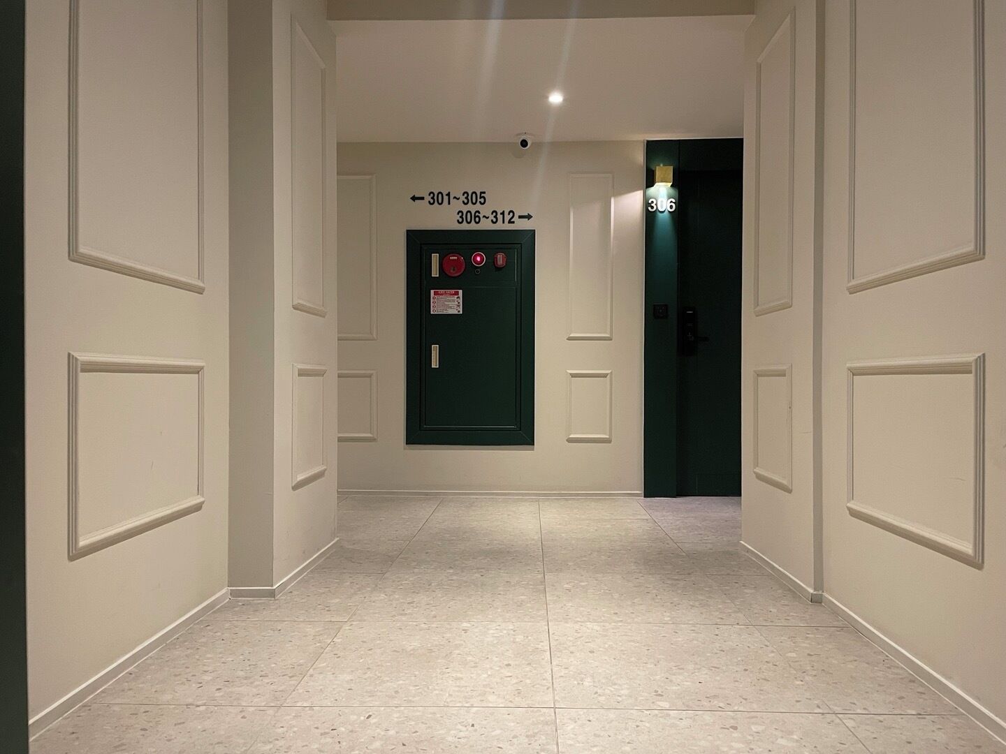 A hallway with doors numbered 301-305 and 306-312, leading to rooms.