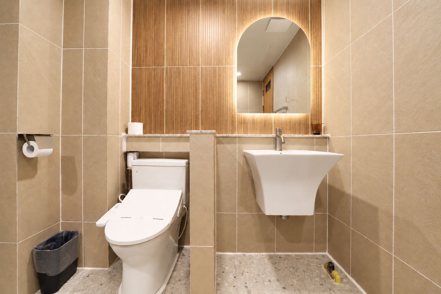 A modern bathroom with a toilet, sink, and mirror.