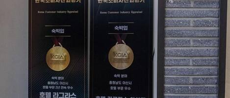 Two KCIA awards for 2023 and 2024 displayed on a wall.