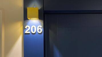 Fachada de edificio con el número '206' iluminado en blanco.