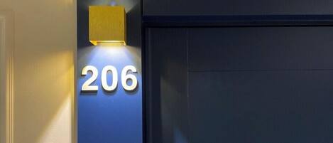 Fachada de edificio con el número '206' iluminado en blanco.