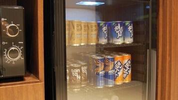 Un minibar con un frigorifero KISTEM, contenente bevande e snack.