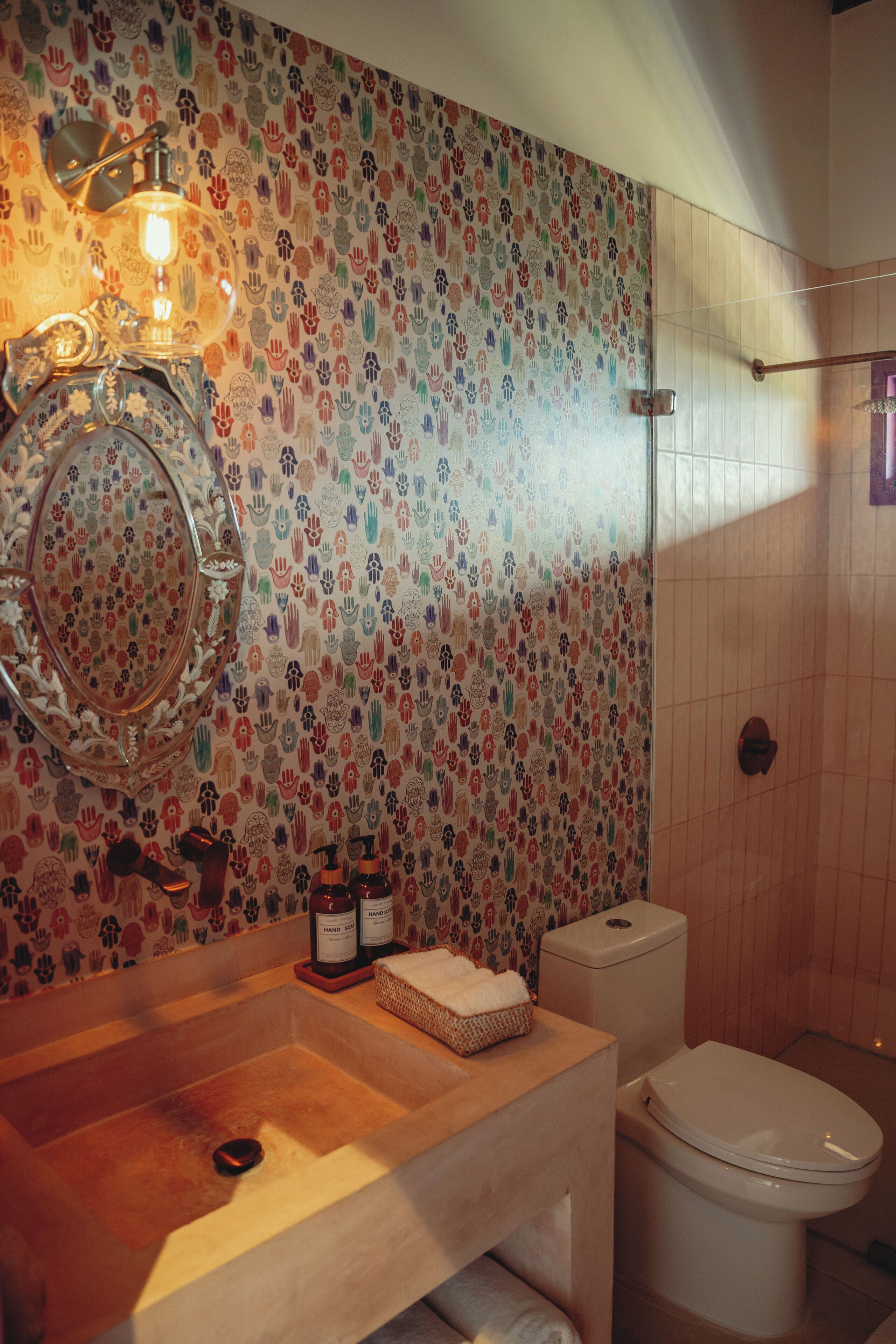 Un bagno con parete piastrellata, lavandino, servizi igienici e zona doccia.