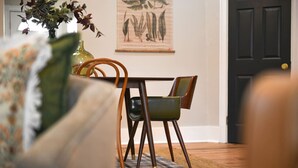A dining area with a table and chairs, a rug, and a door in the background. - ★ HostWise Stays ★ Foxy home, off-street parking, new remodel! (Pittsburgh)