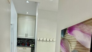 A modern kitchen with white cabinets and a tiled floor.