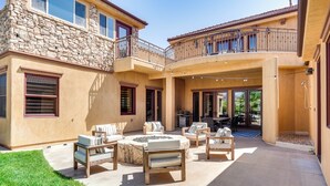 A spacious patio with outdoor furniture, a fire pit, and a stone wall. - Washington Villa 1 Mi to Golf: Great for Groups! (Washington)