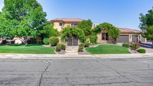 A two-story house with a stone facade, a front porch, and a well-maintained lawn. - Washington Villa 1 Mi to Golf: Great for Groups! (Washington)