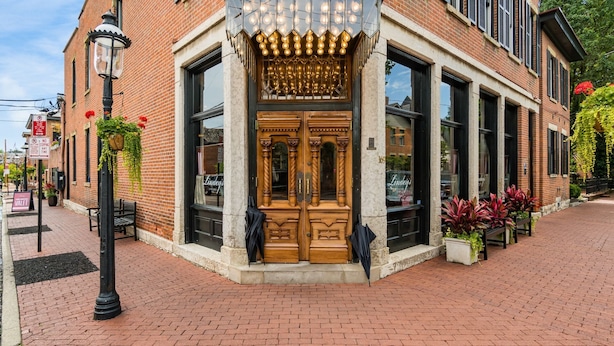 A brick building with large windows and a wooden door. - The Cobbler 's Abode (Columbus)